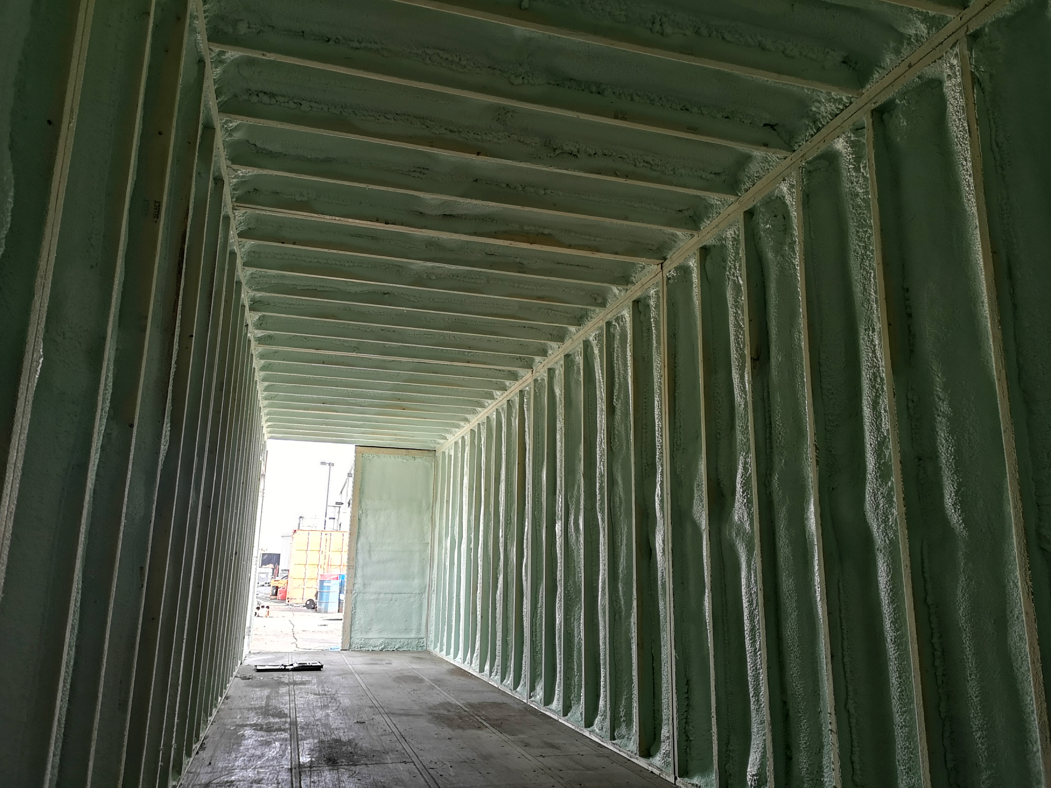 Commercial shipping container insulated with spray foam