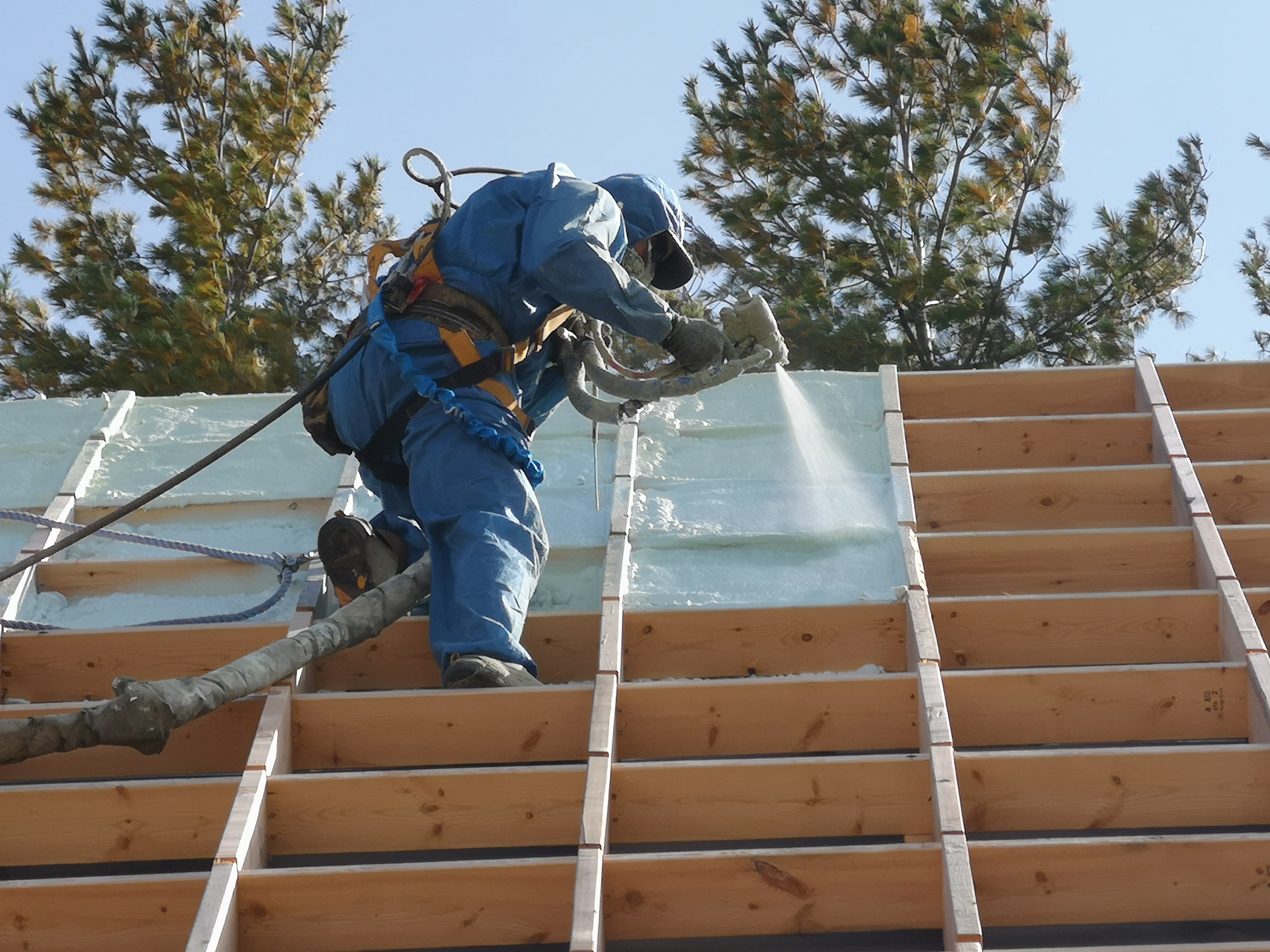 Victory Insulation technician applying spray foam to roof